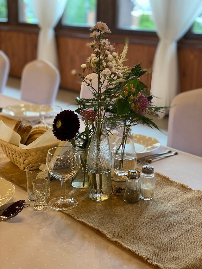 dekoracje na stole na weselu, wazoniki z kwiatami polnymi